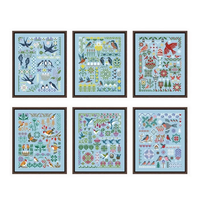 The six Sky Birds sampler designs shown framed together: swallows, goldfinches, kingfishers, hummingbirds, bullfinches and a winter sampler, all on sky-blue fabric