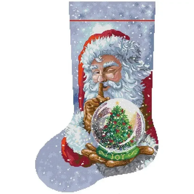 Joy Snow Globe (KB176) Christmas stocking cross stitch design KB176: a winking Santa holding a JOY snow globe with a Christmas tree inside, against a snowy gray-blue sky