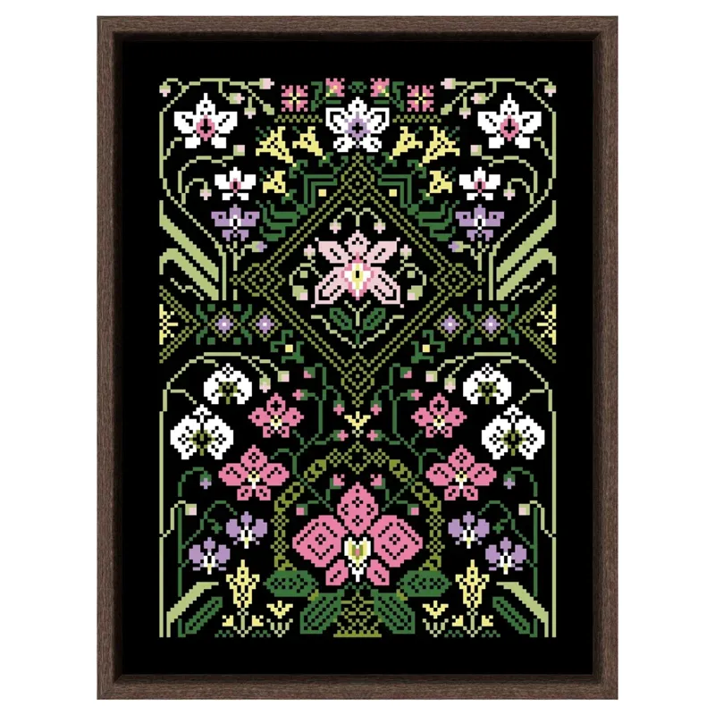 Finished counted cross stitch sampler in a dark wood frame: pink, white, lilac and yellow art nouveau flowers around a green diamond medallion, stitched on black Aida fabric
