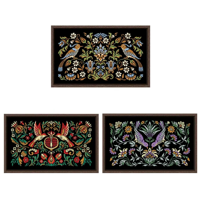 The three Night Songs bird designs shown framed side by side: the turquoise, pomegranate and amethyst birds, each worked on black fabric