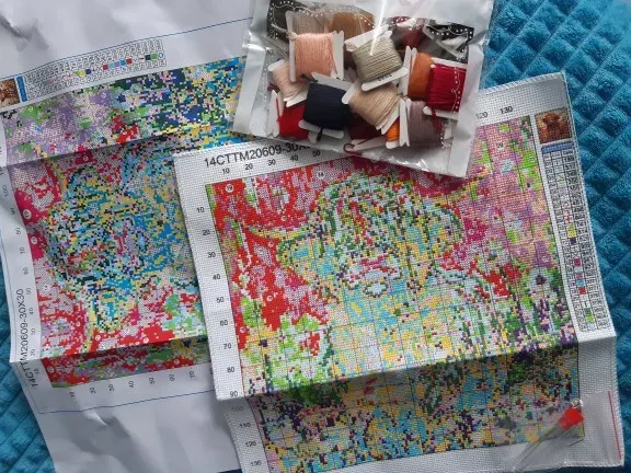 Buyer photo of the Highland Cow kit received: the color-printed fabric, two chart sheets and a bag of thread cards