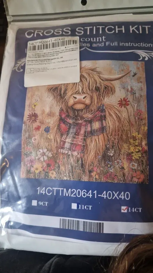 Buyer photo of the Highland Cow kit pouch: the cow in a tartan scarf on the blue Cross Stitch Kit packaging, 14CT checked
